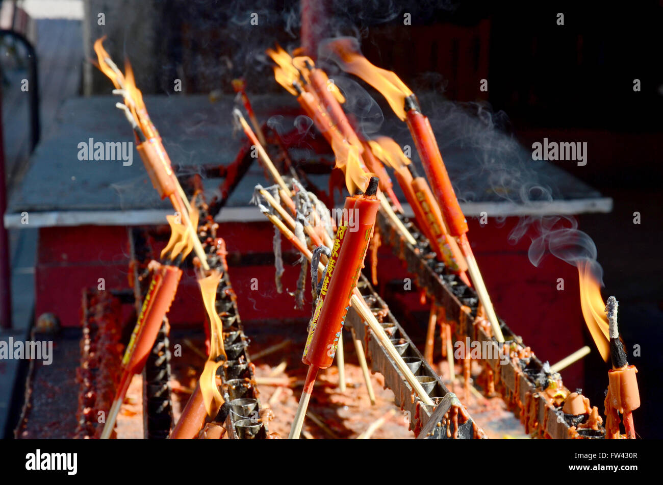 People burning incense and red candle for pray god at Suphanburi city
