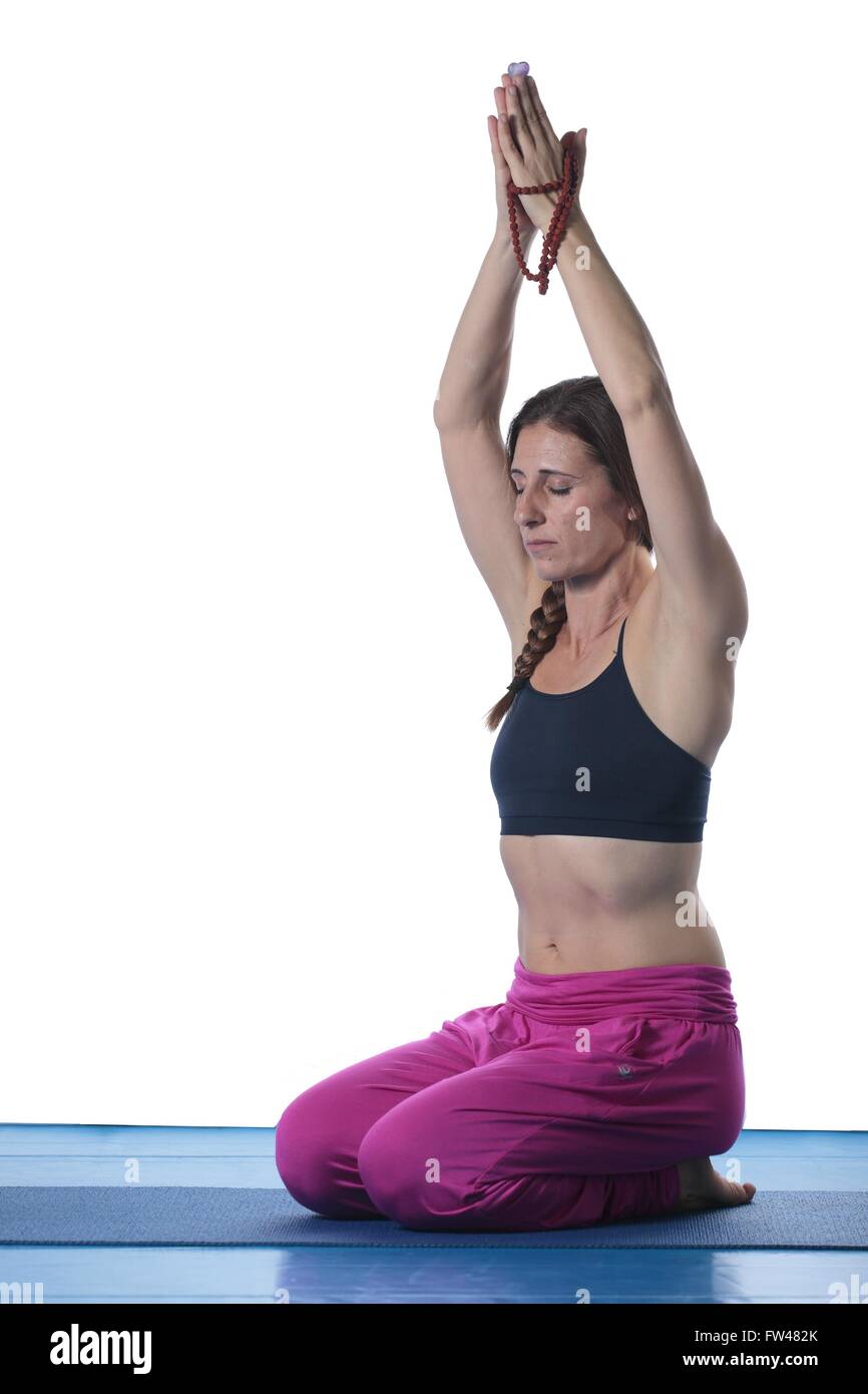 Woman practicing yoga on a mat and white background Stock Photo - Alamy