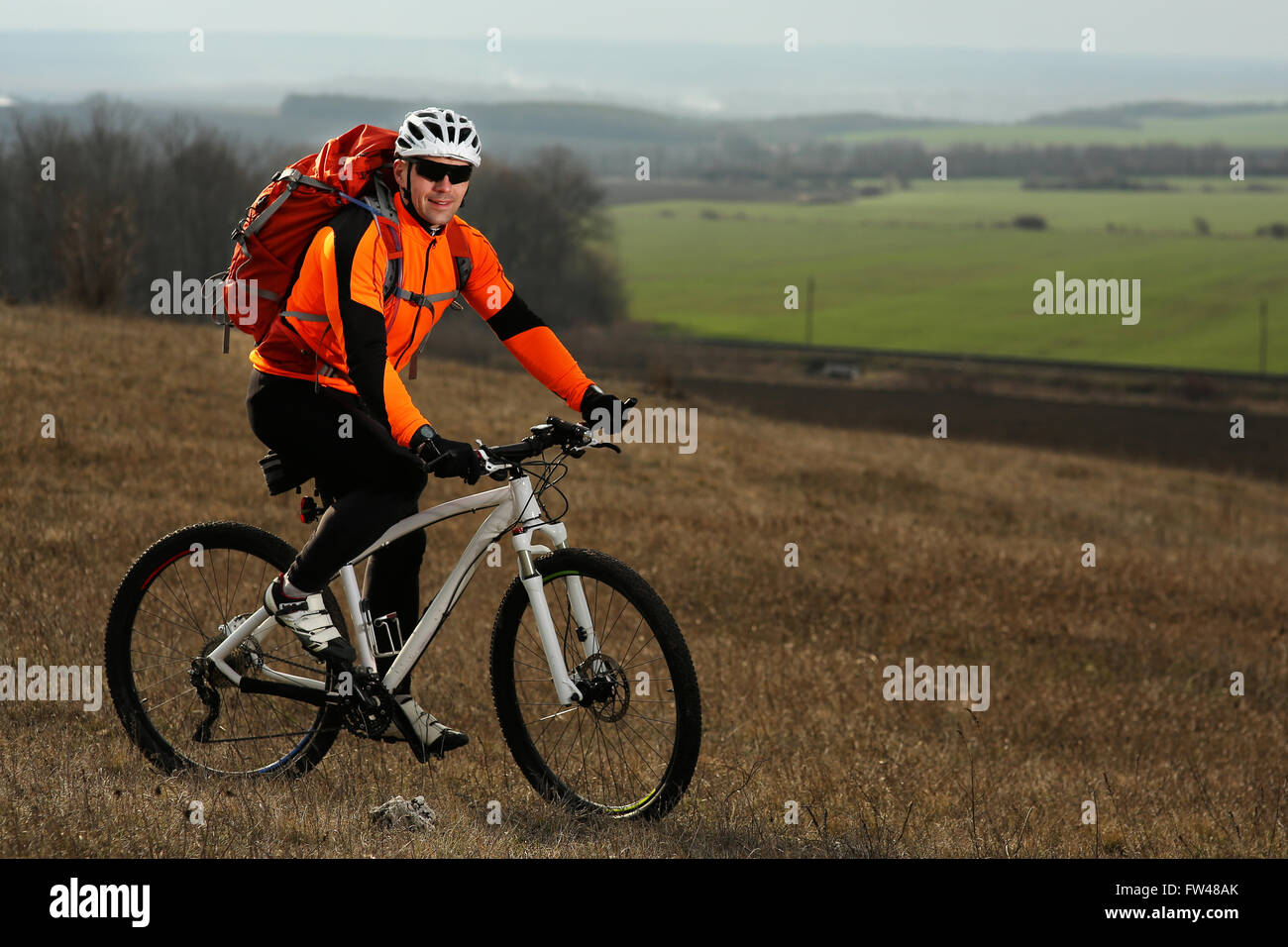 Backpack Riding Position Man cyclist with backpack riding the bicycle Stock Photo - Alamy