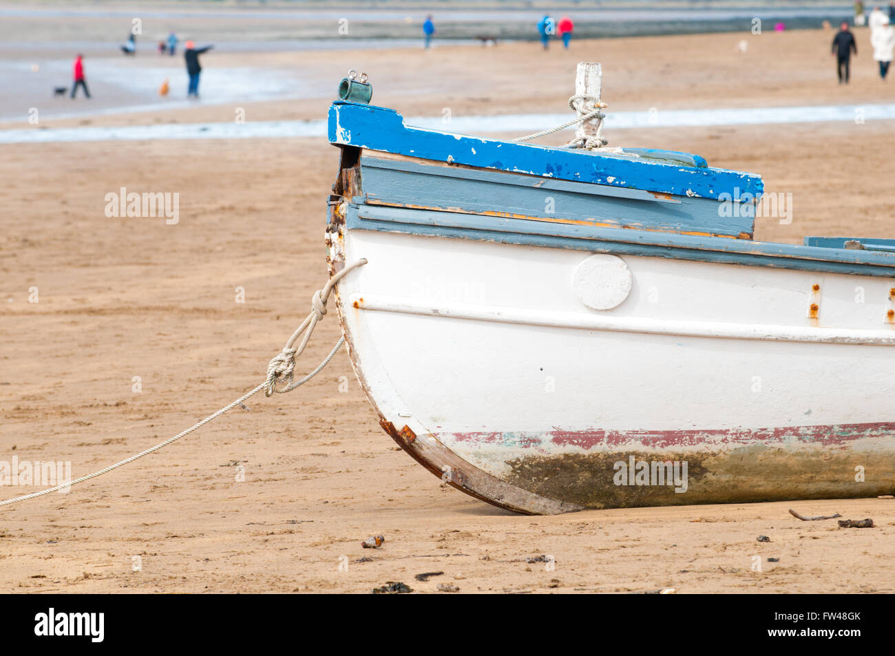 An old fishing boat moored on the beach at low tide Stock Photo