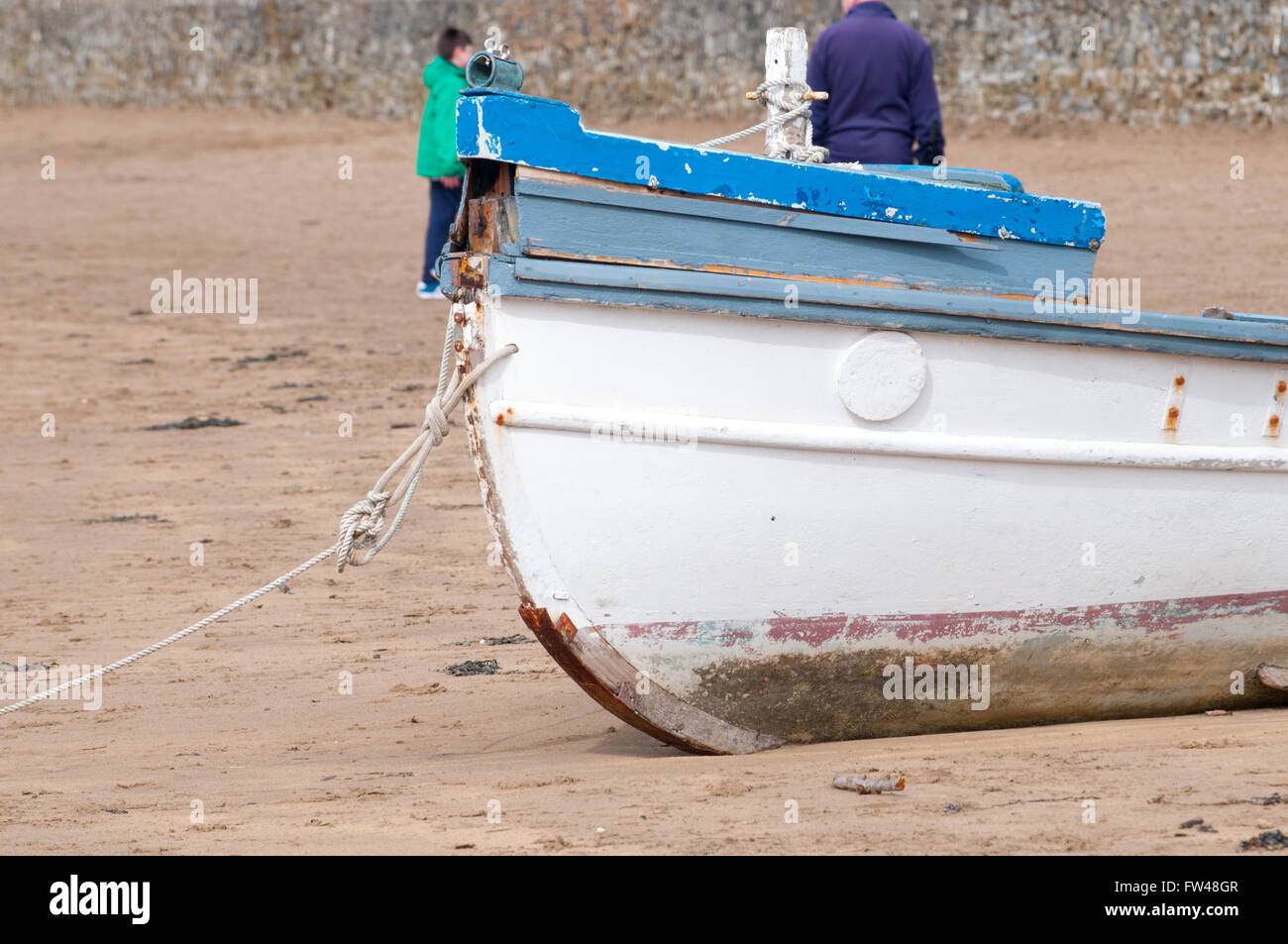 An old fishing boat moored on the beach at low tide Stock Photo - Alamy