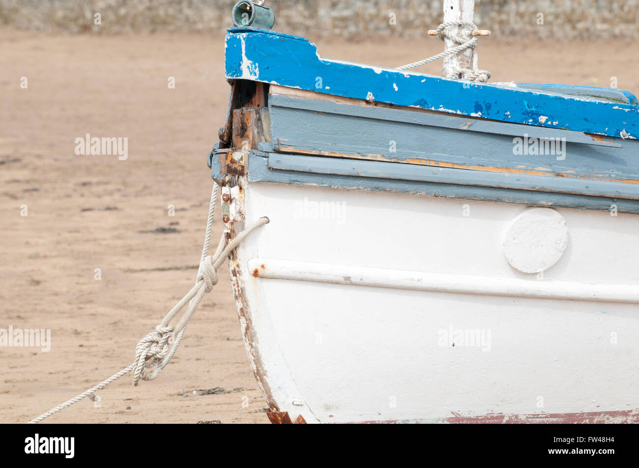 An old fishing boat moored on the beach at low tide Stock Photo