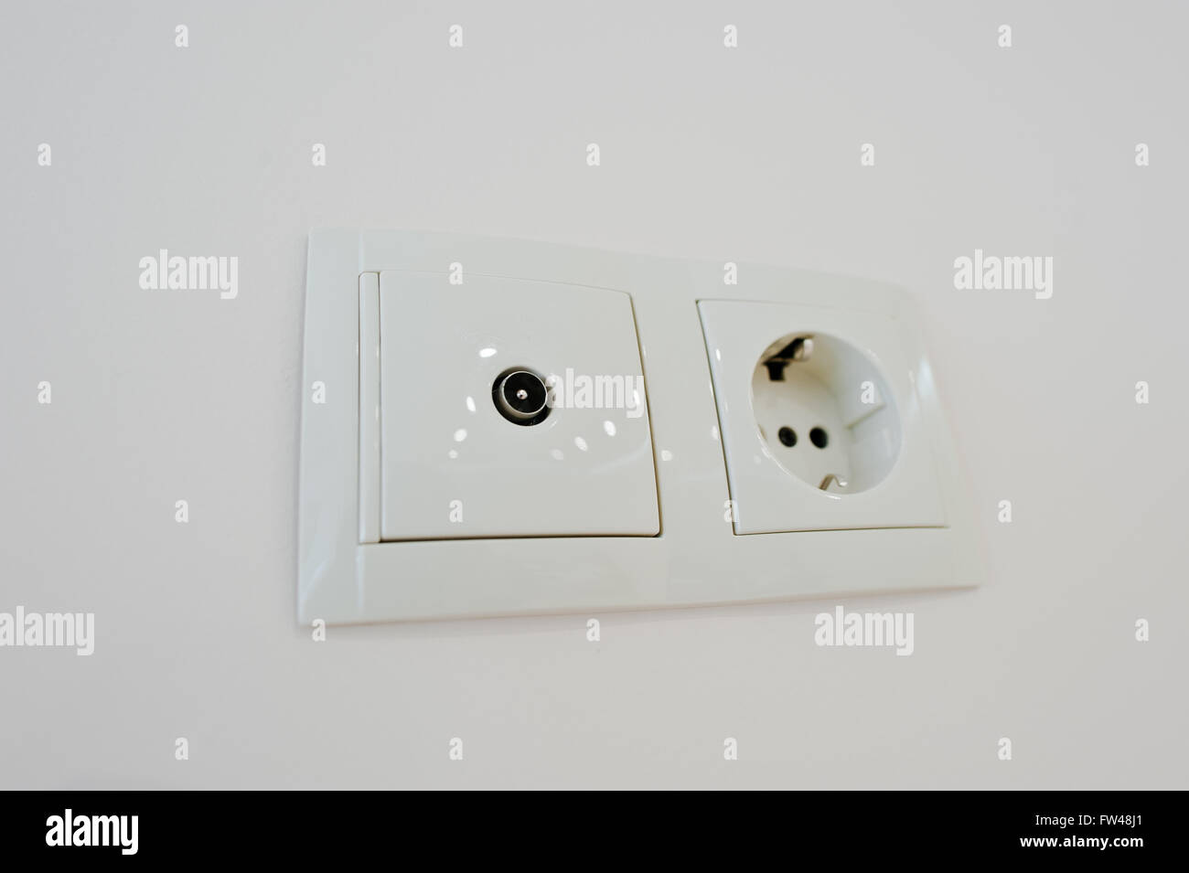 Twin electric socket with tv plug at the wall Stock Photo - Alamy