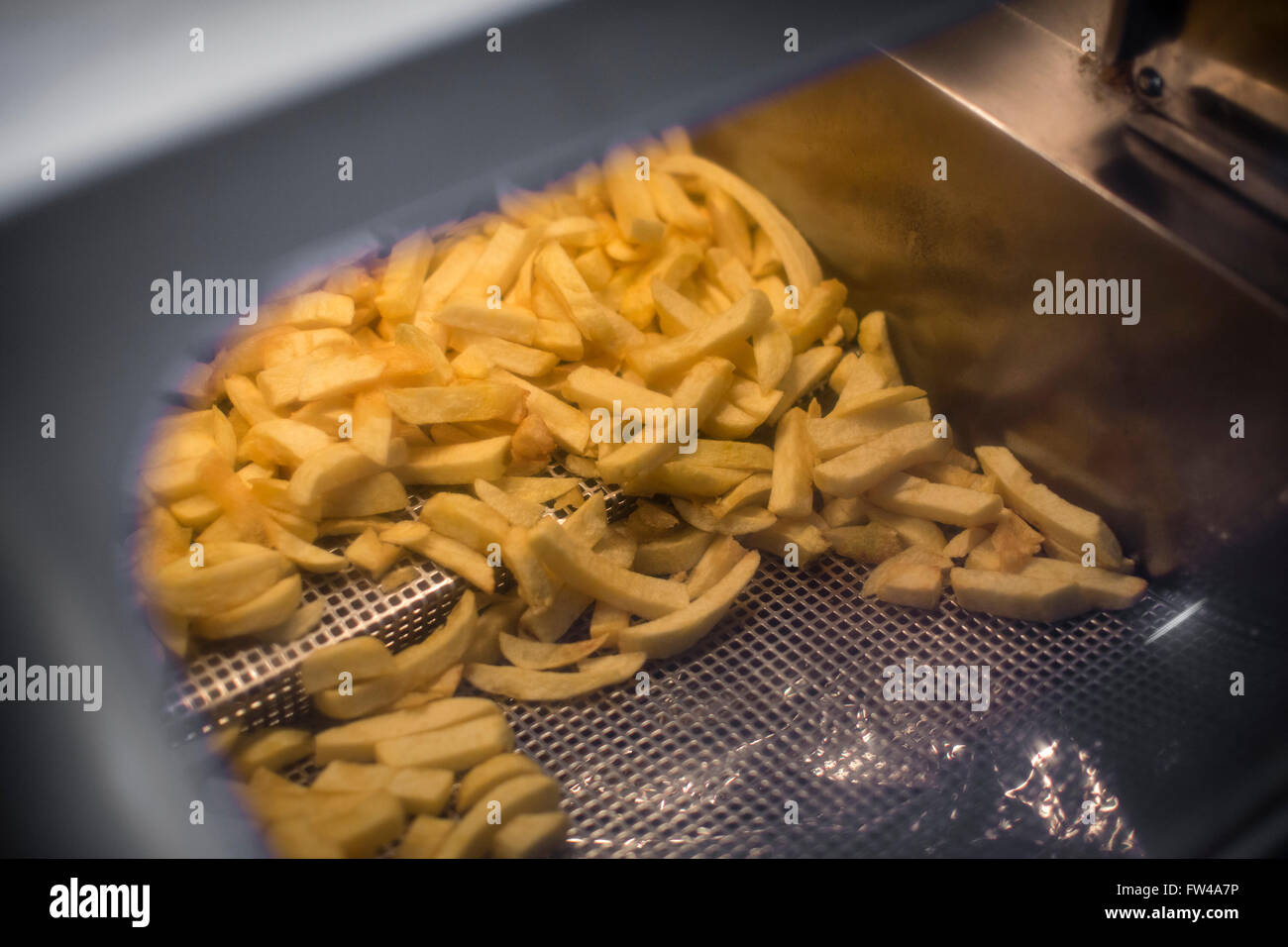 Fish & Chip shop in Cheltenham UK with a pile of chips keeing warm ina large metal chip drawer. Stock Photo