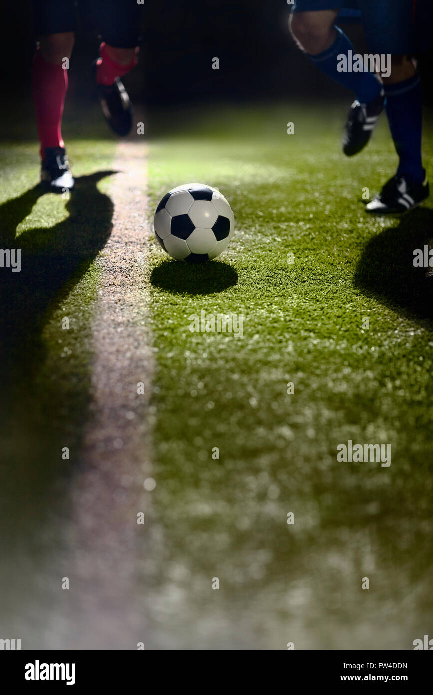Two soccer players running towards a soccer ball Stock Photo - Alamy