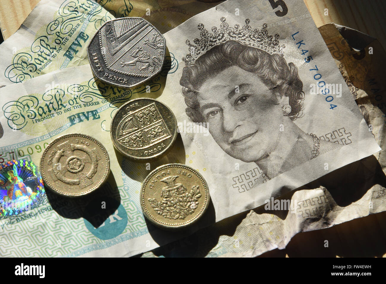 UK Currency Sterling Five Pound Notes And Various Coins Stock Photo