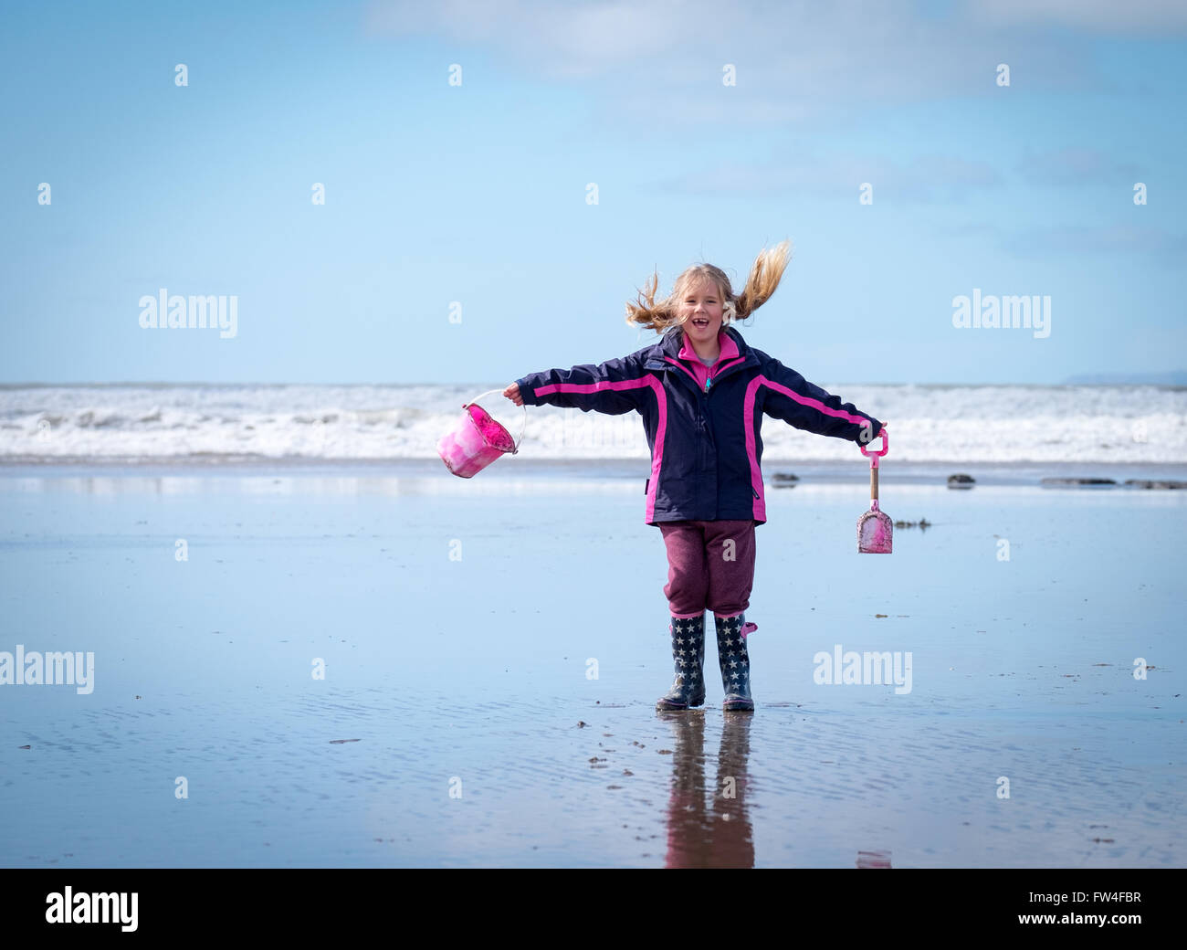 A girl playing on an empty beach in Westward Ho!, Devon in the UK Stock Photo