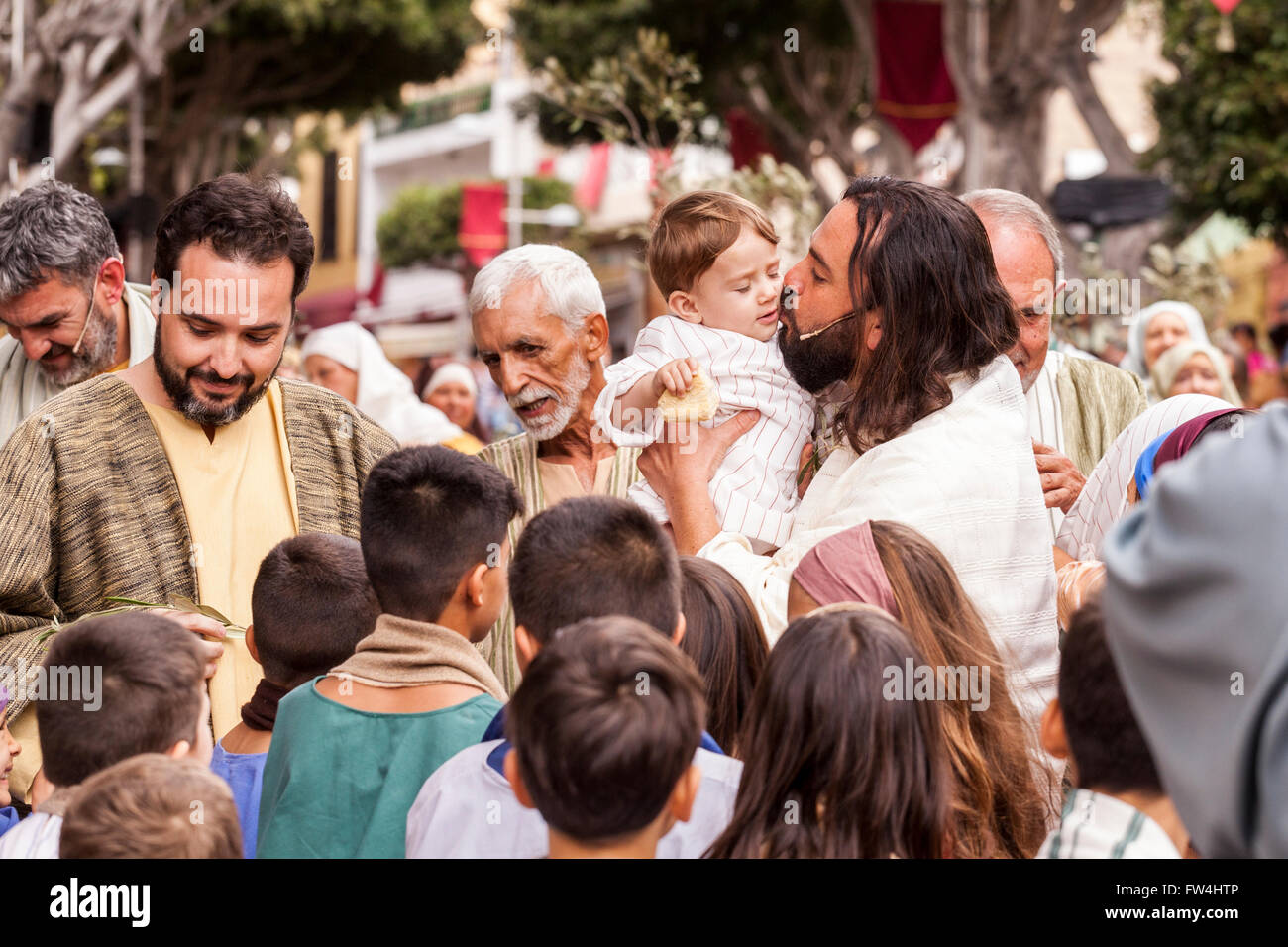 Actor playing Jesus kisses a baby in the Passion play, Adeje, Tenerife, Canary Islands, Spain. Representacion de la Pasion. Adej Stock Photo