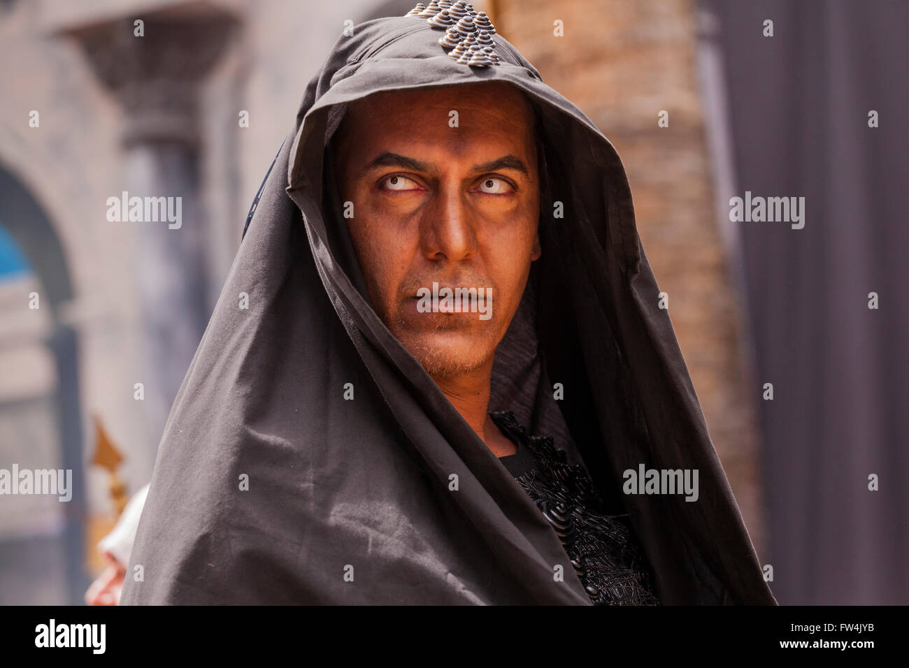 Actor with contact lenses and dark hood playing Satan in the Passion play, Adeje, Tenerife, Canary Islands, Spain. Representacio Stock Photo