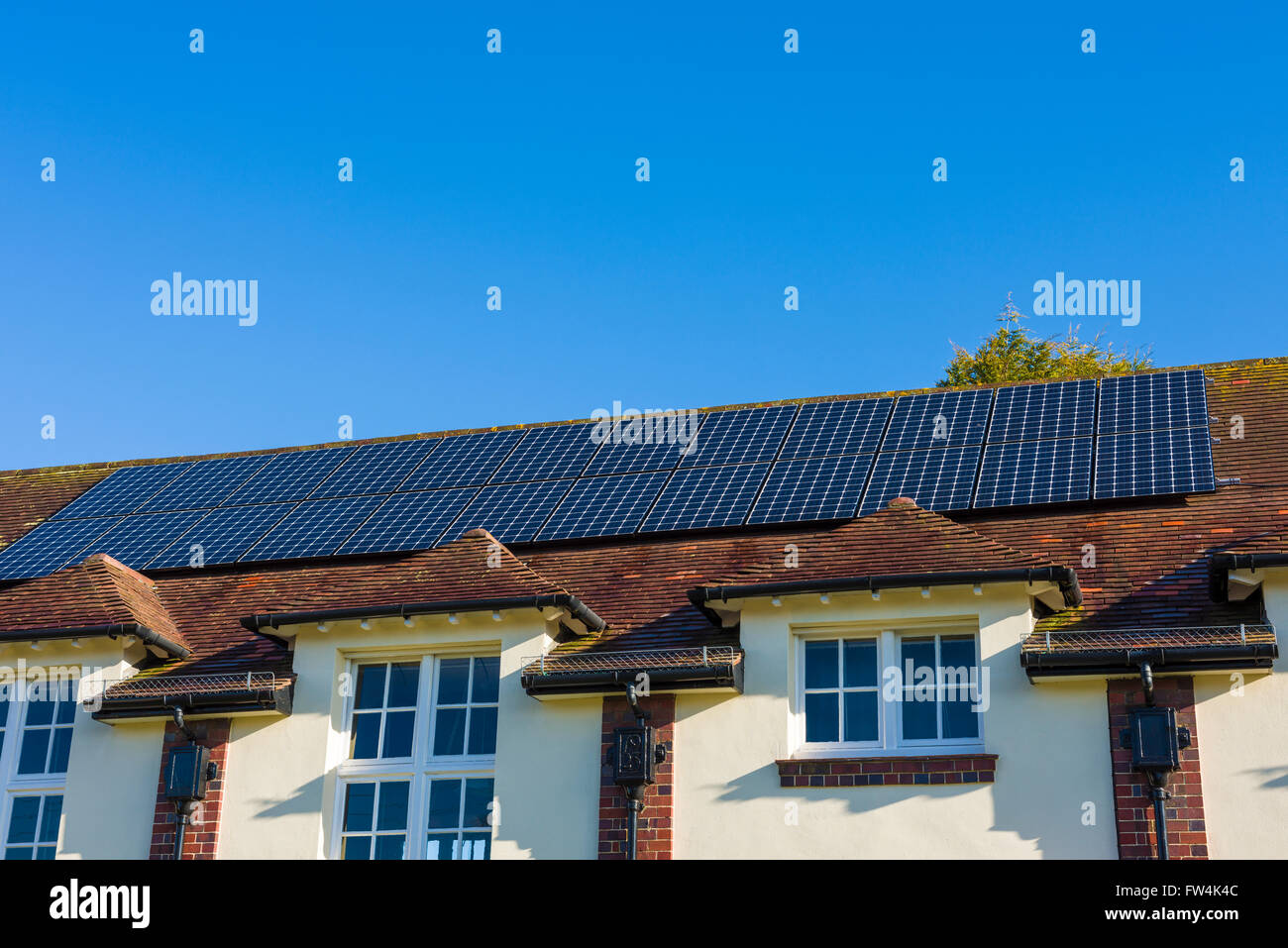 Photovoltaic solar panels on the roof of a village hall. Wrington, North Somerset, England. Stock Photo