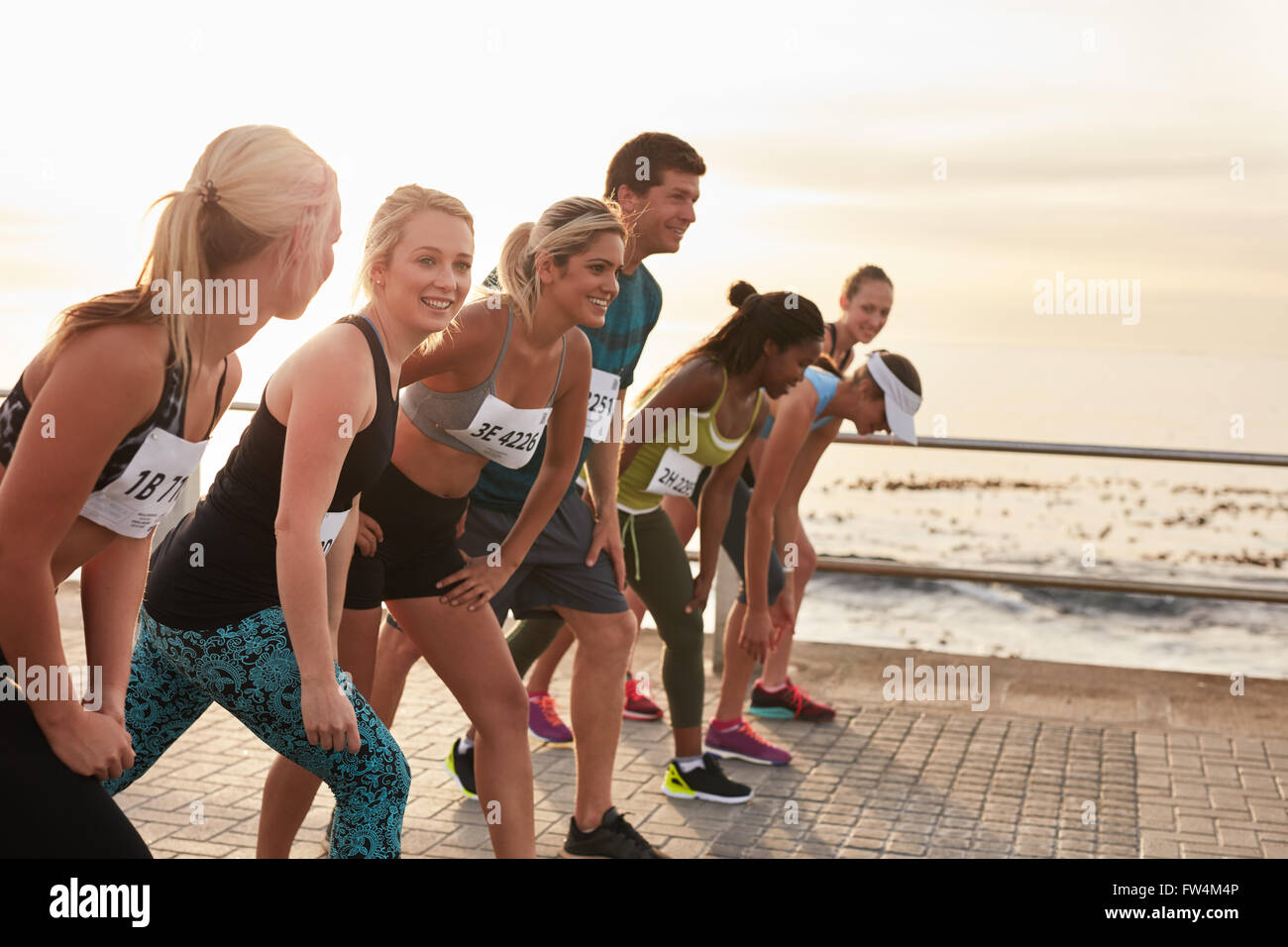 The start of a marathon, athletes standing at the starting line. Running competition on seaside promenade. Stock Photo