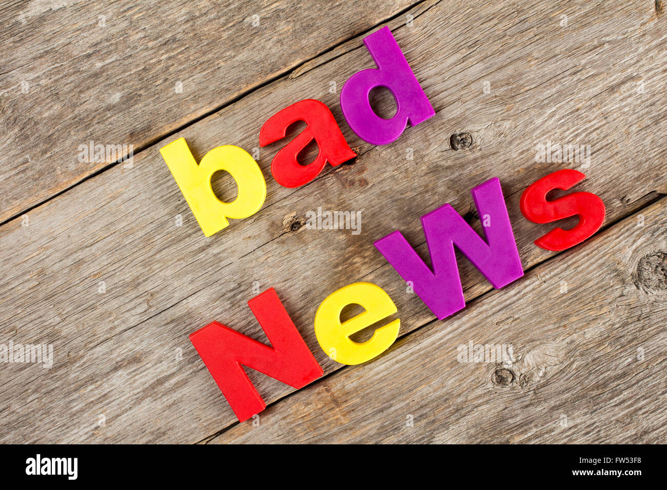Colored letter magnets spelling text BAD NEWS Stock Photo