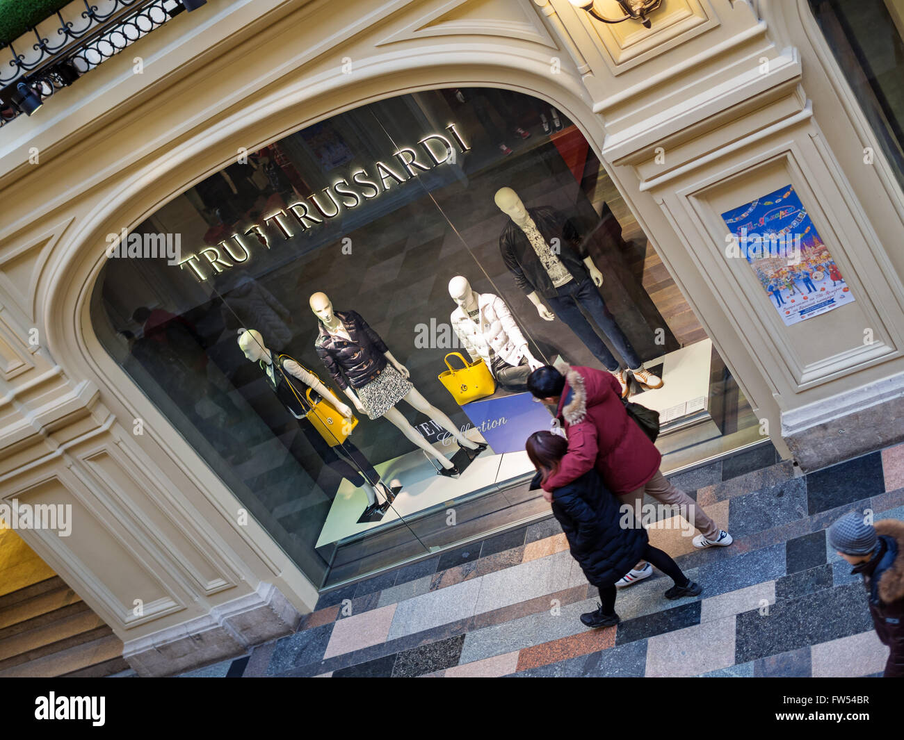 Red Square, Moscow, Russia - February 21, 2016: Chinese tourists pass near TRU Trussardi boutique showcases at the GUM Departmen Stock Photo