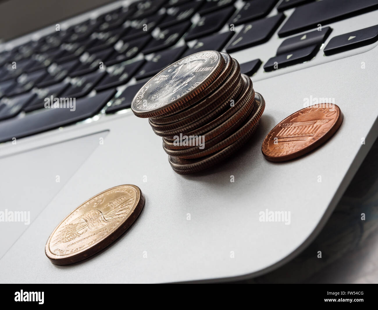 Personal Finance - US coins on a laptop keyboard, shallow depth of field Stock Photo