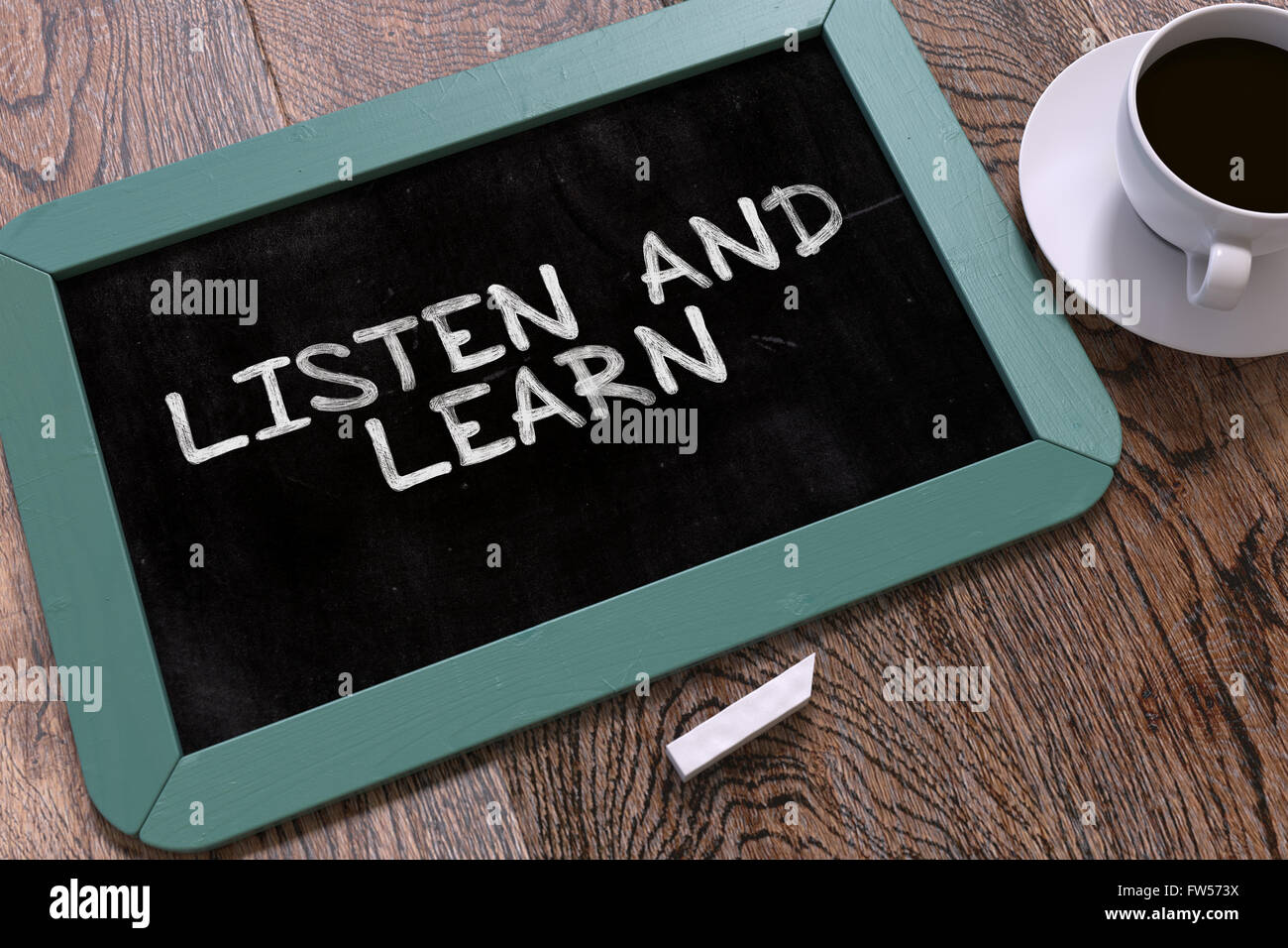 Handwritten Listen and Learn on a Chalkboard. Stock Photo