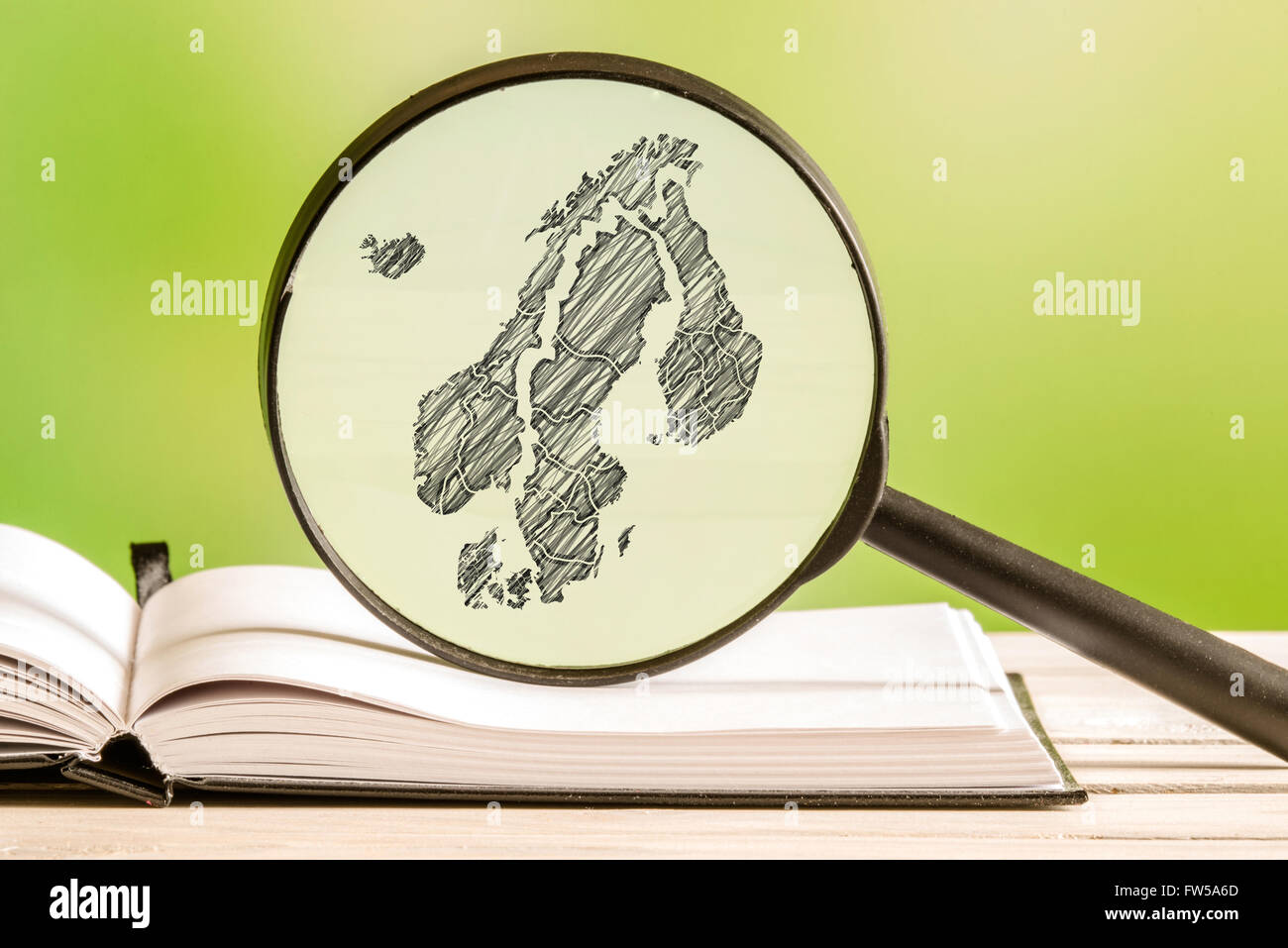 Scandinavia information with a pencil drawing of a scandinavian map in a magnifying glass Stock Photo