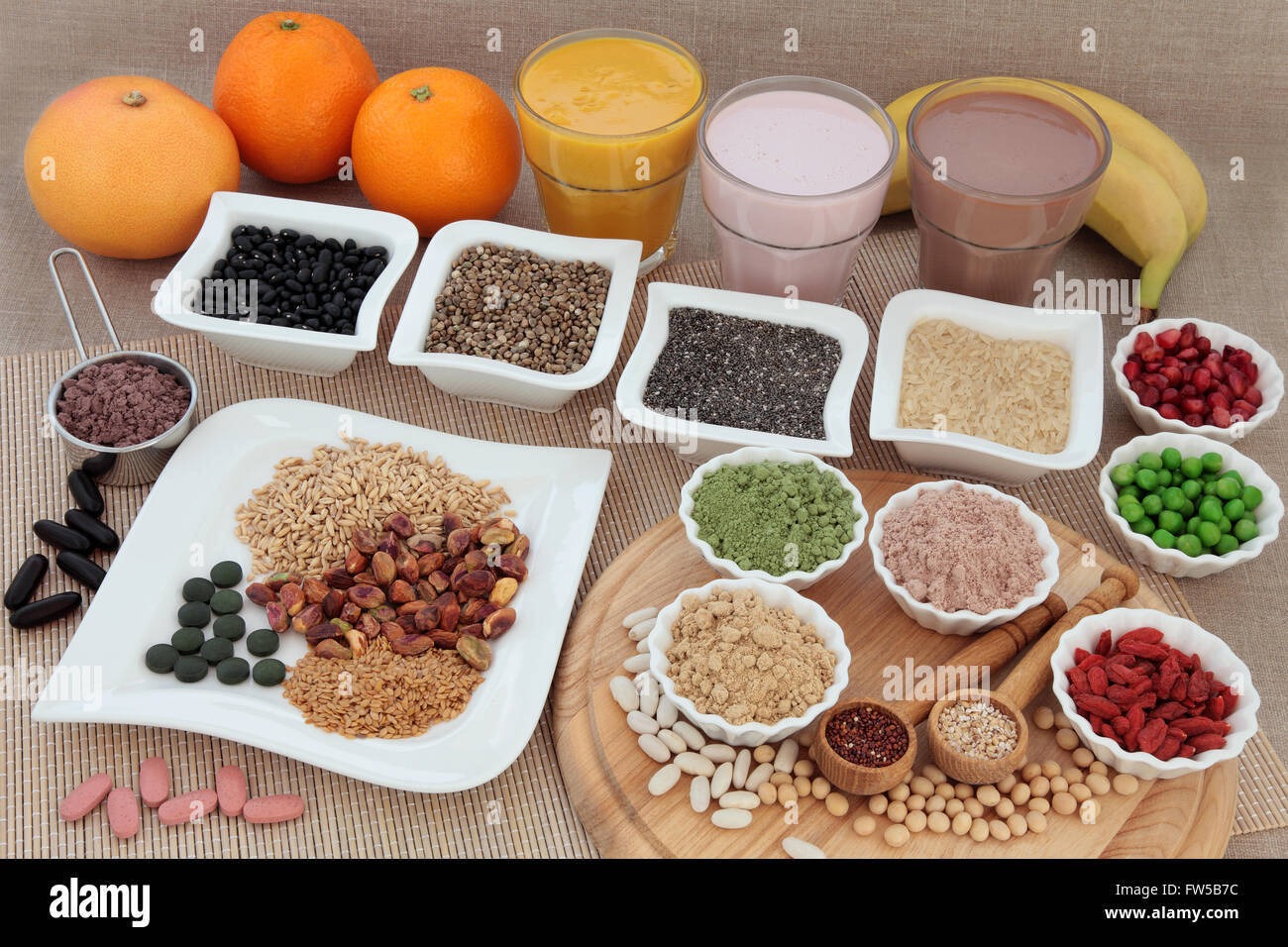 Body building high protein food with supplement powders, vitamin pills, fruit smoothie shakes, grains, seeds, fruit and nuts Stock Photo