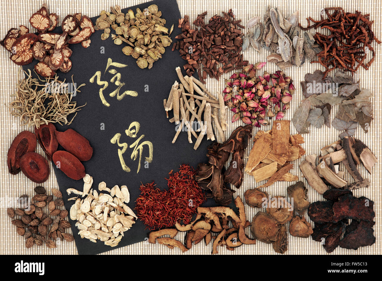 Yin and yang symbols with traditional chinese herbal medicine selection on bamboo. Translation reads as yin and yang. Stock Photo