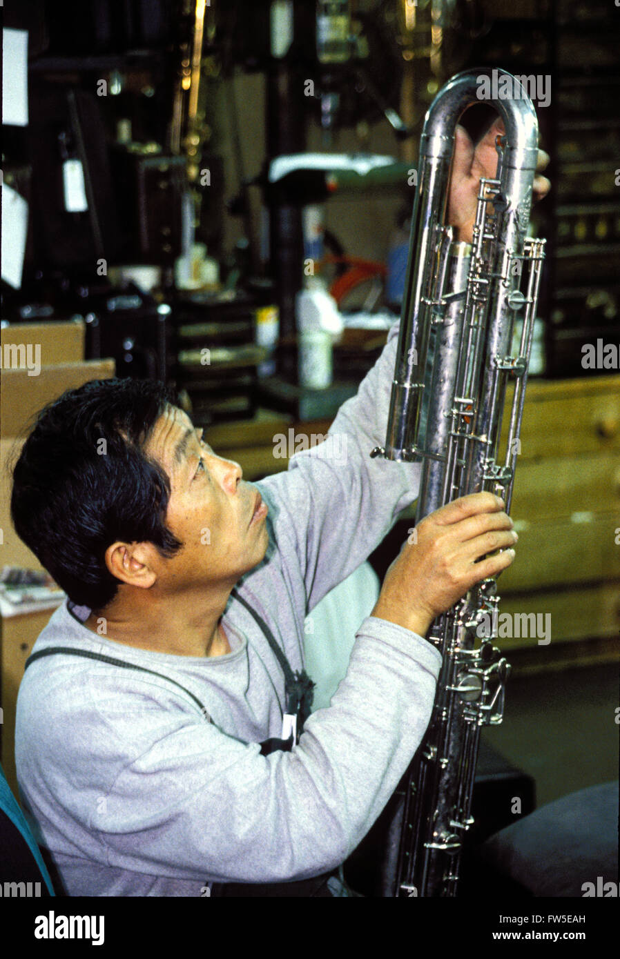 Japanese woodwind technician, repairing a contra-bass clarinet, Tokyo ...