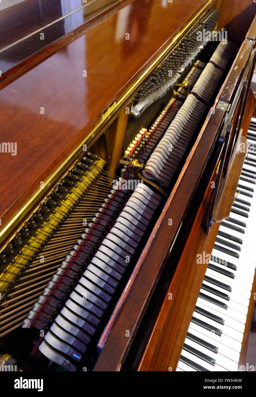 Piano mechanism - lid opened of Steinway upright piano, 1909, to reveal hammers, dampers, pressure bars; NB 8 (red) fly dampers, B to F#, by break at cross-over, to ensure equal damping Stock Photo
