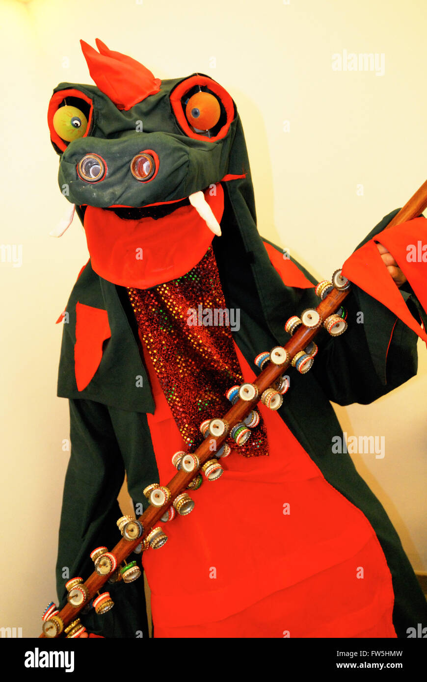 dragon in costume for morris dancing, West Sussex, holding 'zob stick',  pole with bells made of bottle tops Stock Photo