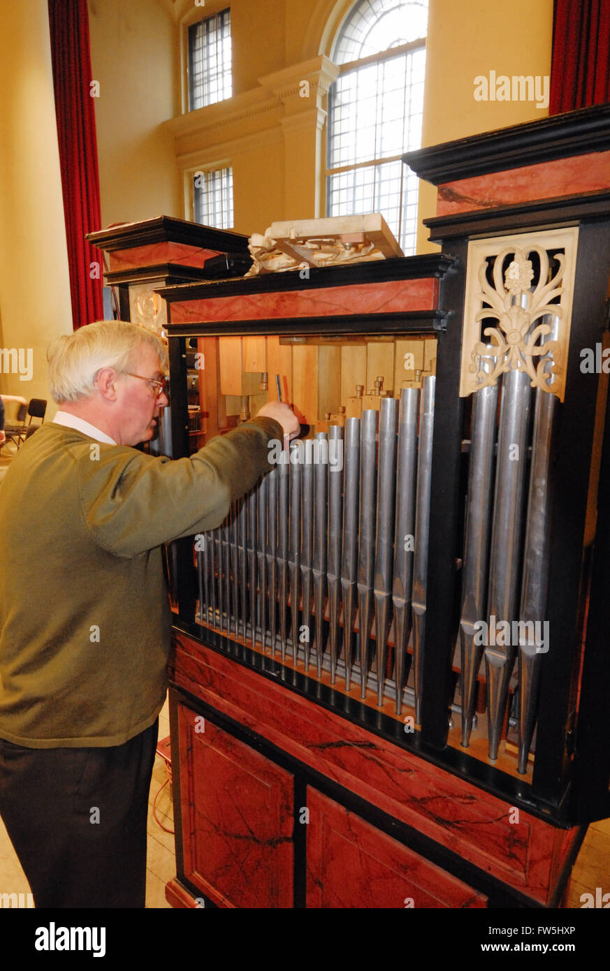 Michael Broadway of N. P. Mander pipe organ builders, tuning chamber organ by Mander for Christmas Oratorio performance in St. John's Smith Square Stock Photo