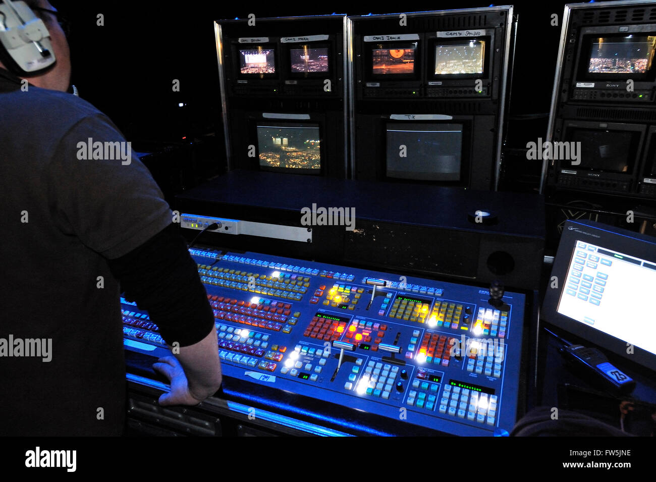 backstage mixing desk, control panel and production monitor screens, as used to balance sound and choose camera shots in a large stadium, such as here on a UK tour by Andrea Bocelli, tenor. Stock Photo