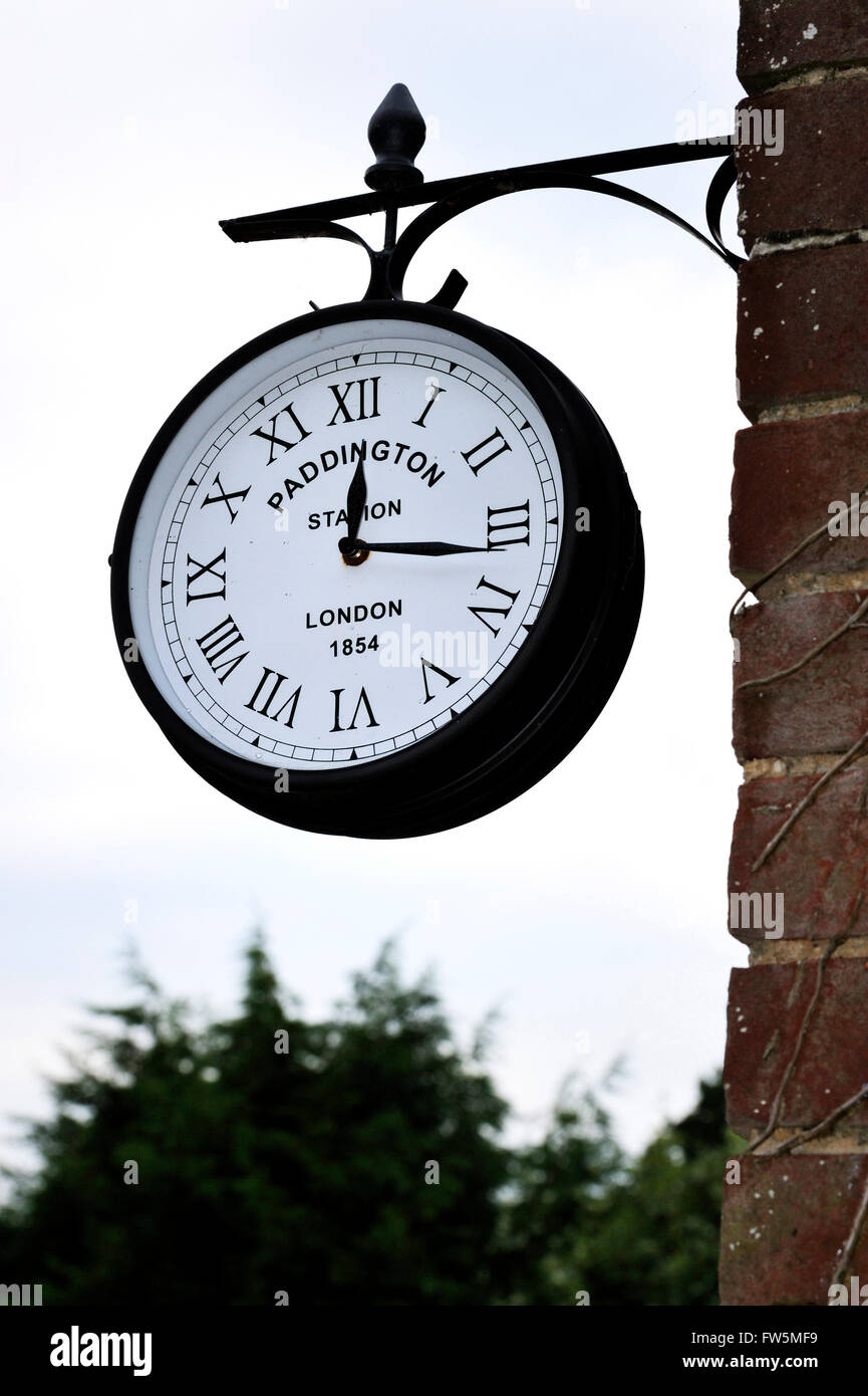 Small copy of Paddington Station clock, dated 18, on garden wall of The