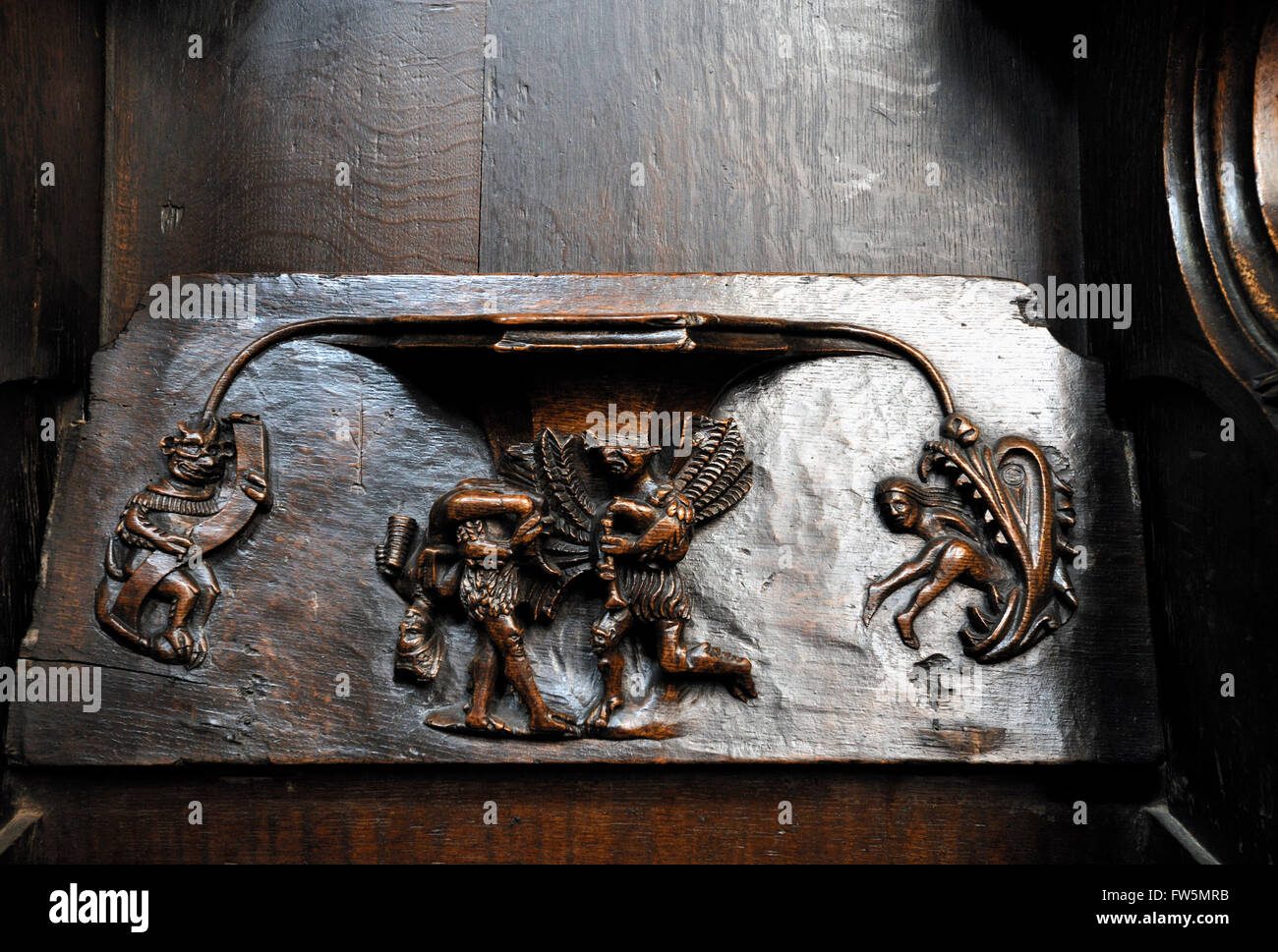 15th century carve15th century carved misericord in the choir, in oak, of Virgin and Child, in St Laurence's Church, Ludlow, Shropshire. sbowing tormented souls and devils, one playing the bagpipes.d misericord in the choir, in oak, of Virgin and Child, in St Laurence's Church, Ludlow, Shropshire. sbowing tormented souls and devils, one playing the bagpipes. Stock Photo