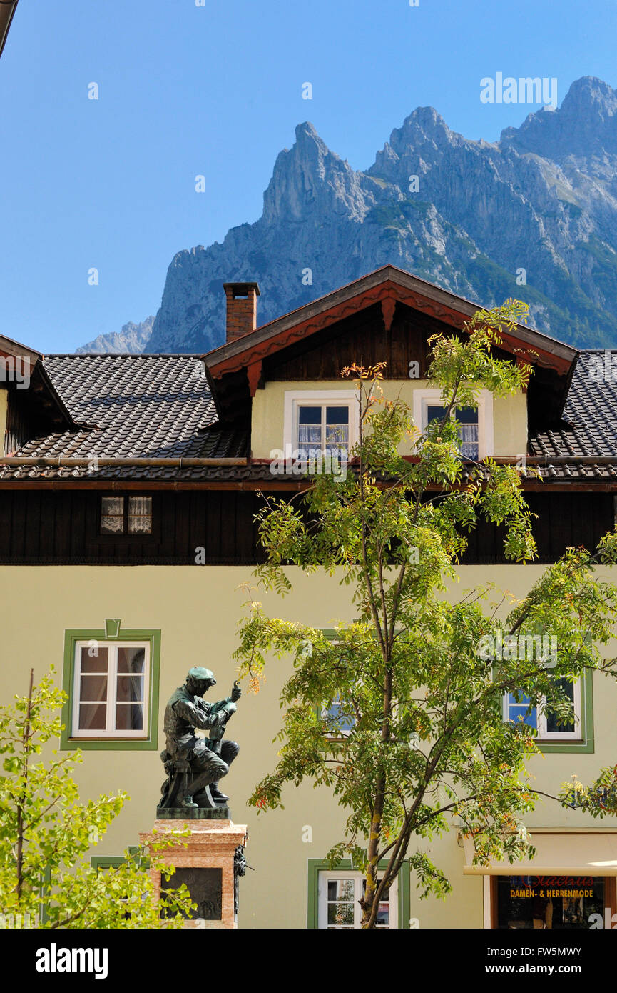 statue of violin maker Meister Matthias Klotz (1653-1743), father of the Mittenwald violin building tradition; Mittenwald, Bavaria, is still the violin making centre of Germany. With the Karwendel mountain (Bavarian Alps) behind, and painted houses. Stock Photo