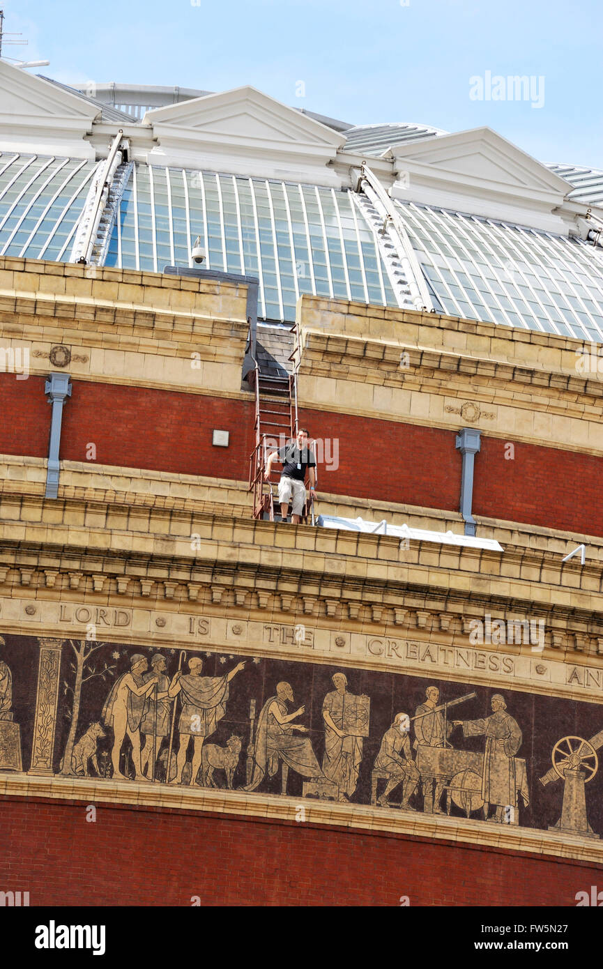 worker descending from fire ladder, down from the glass dome of London's Royal Albert Hall, concert hall. The Royal Albert Hall was built to fulfil the vision of Prince Albert (Queen Victoria's consort) of a 'Central Hall' that would be used to promote understanding and appreciation of the Arts and Sciences. The list of famous performers and world figures who have appeared since it opened in 1871 is unrivalled. Wagner, Verdi and Elgar conducted the first UK performance of their own works on its concert platform, Rachmaninov played his own compositionsand nearly every major classical solo artis Stock Photo