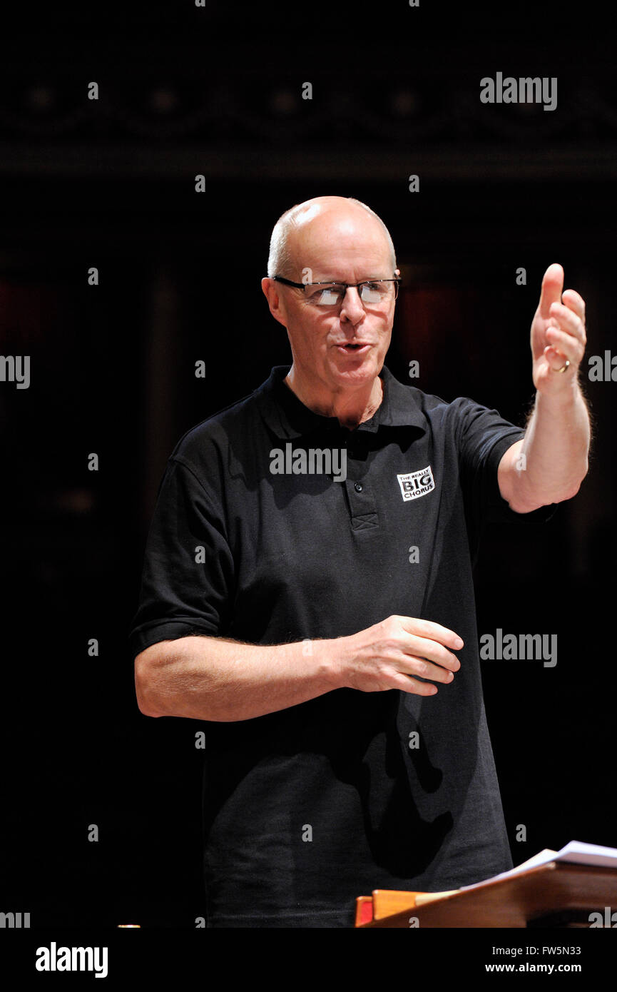 Brian Kay, conductor, in rehearsal with The Really Big Chorus and orchestra for Concerts From Scratch (and wearing T-shirt logo), Royal Albert Hall, London: Handel's Messiah. Has just taken over the musical directorship of the RBC. Conductor, presenter for BBC Radio and Televsion, a founder member 1978 and bass singer with The King's Singers, conductor of Vaughan Williams' Leith Hill Musical Festival in Surrey; he also sang the voice of Papageno in the Hollywood movie ÔAmadeus' (his wife, the soprano Gillian Fisher sang Papagena), has been the lowest frog on a Paul McCartney single, one of the Stock Photo