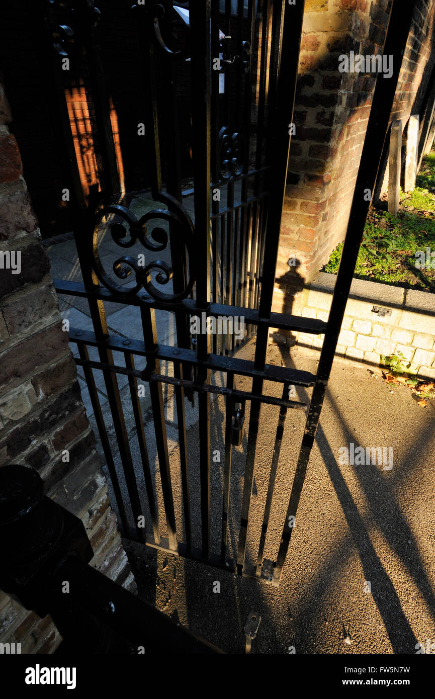 shadows cast by the only remaining gates of the Marshalsea Prison; at Borough High St., Southwark, by St George's church. John Dickens, father of English novelist Charles Dickens, was imprisoned here for debt in 1824 for a few formative years in his son's youth; Charles lived nearby in Lant St., while working at Warren's blacking factory, and this wretched time was described in his near- autobiographical novel, David Copperfield. The prison dates from medieval times and was closed in 1842. Amy Dorrit's father, William, was also imprisoned at the Marshalsea, and St. George's church where Amy Do Stock Photo