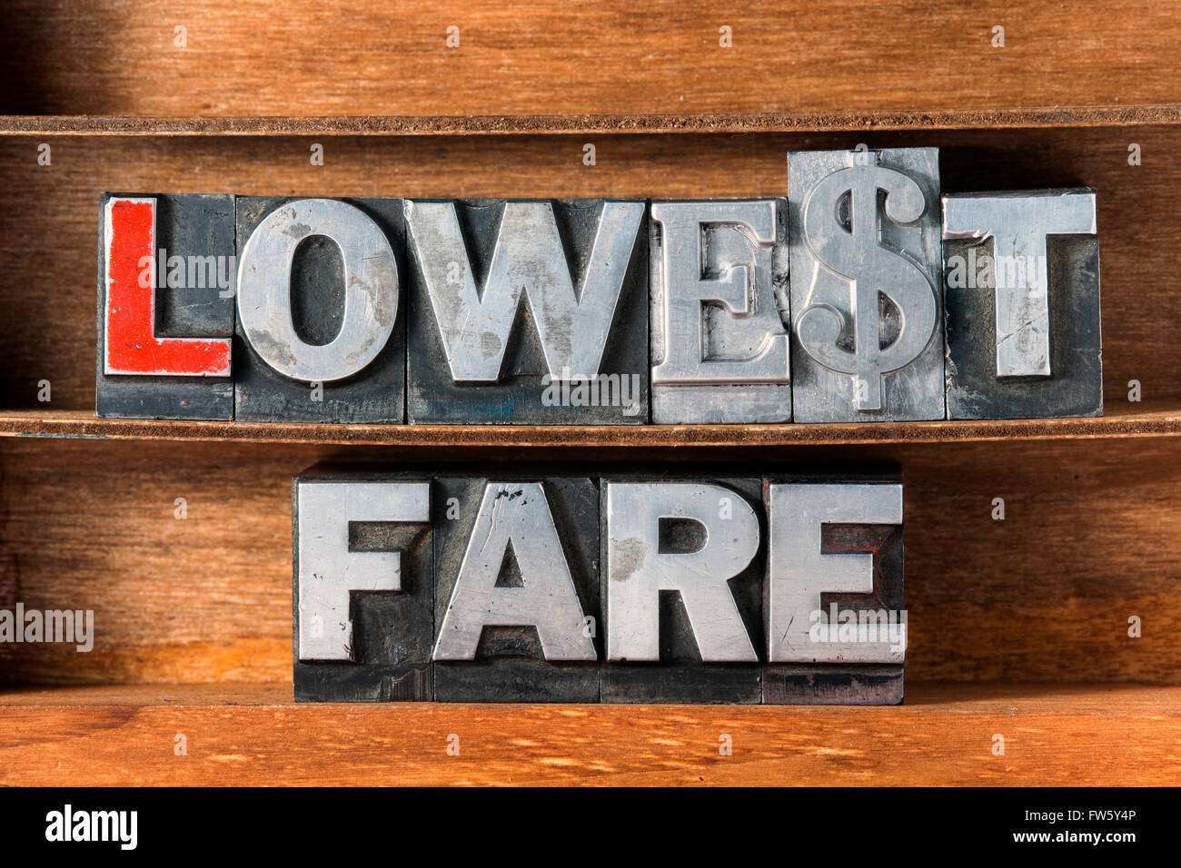 lowest fare phrase made from metallic letterpress type on wooden tray Stock Photo