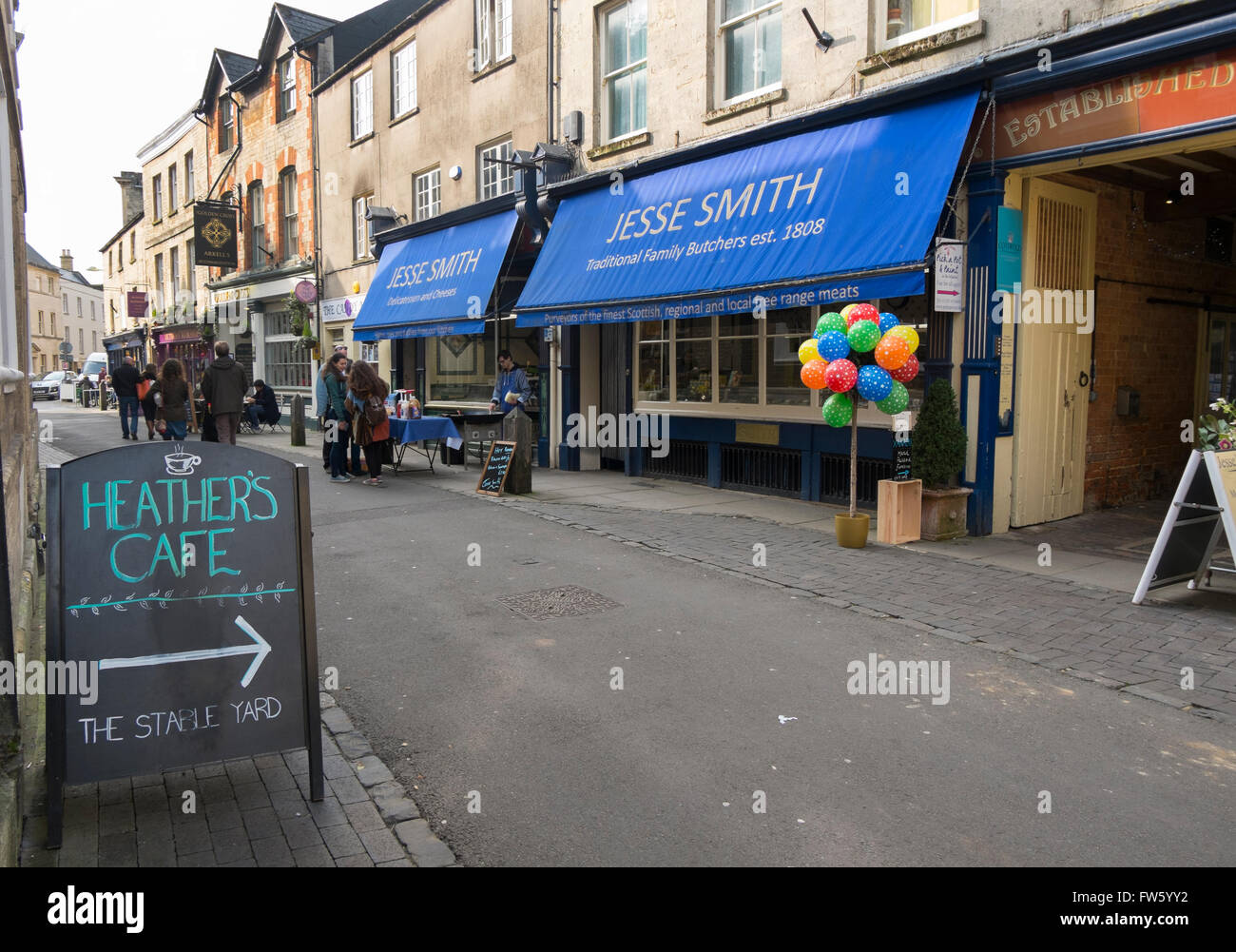 Burgers and sausages being cooked outside Jesse Smith butchers in Black Jack Street, Cirencester, Gloucestershire, UK Stock Photo