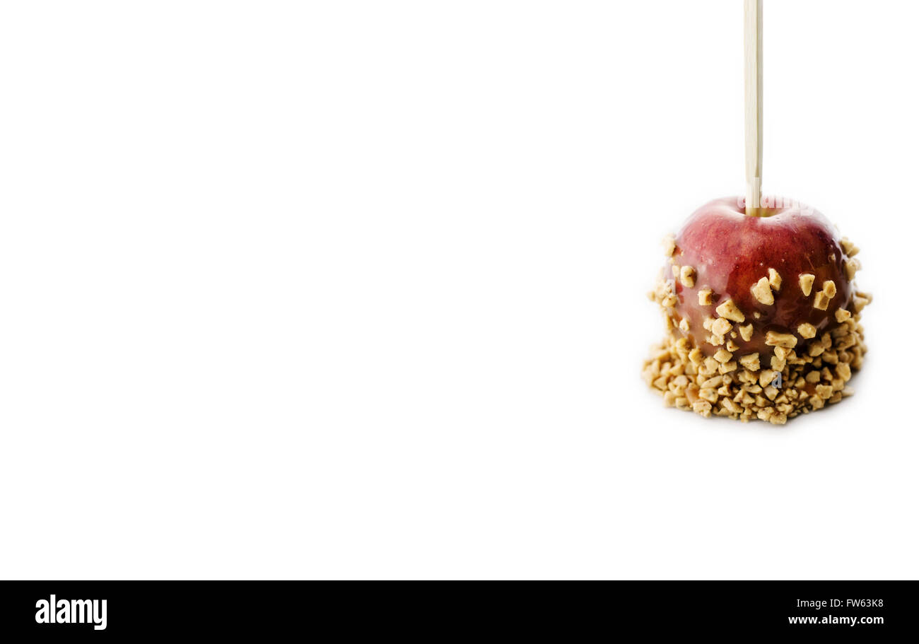 Single caramel apple with nuts and toffee bits isolated on white