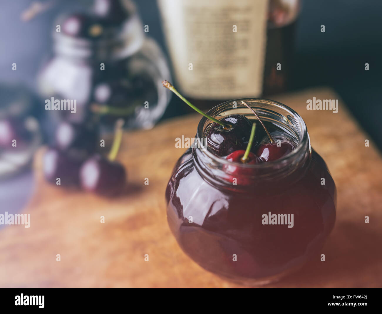 Fresh cherries in a jar filled with bourbon Stock Photo Alamy