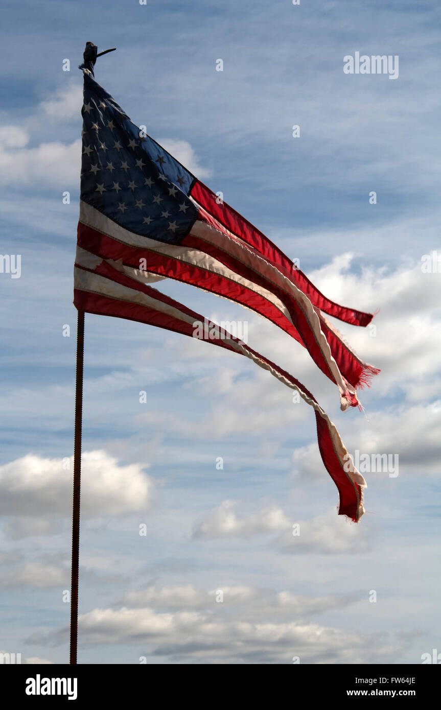 Tattered, waving American flag, star spangled banner, U.S. symbol of triumph Stock Photo