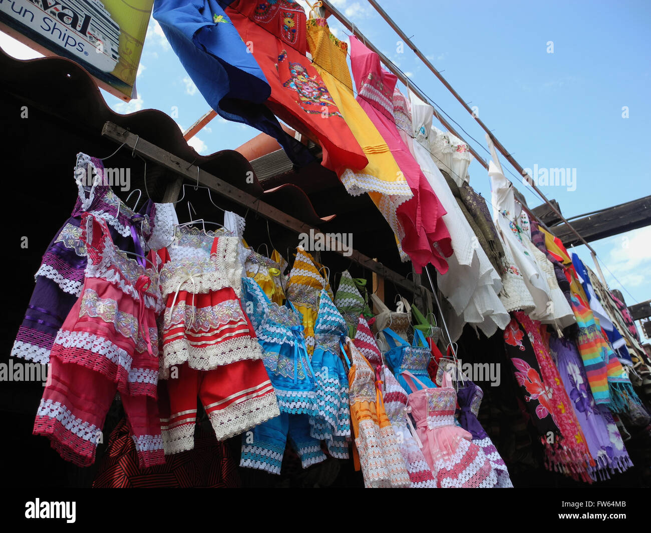 brightly colored clothes for sale at stand in Mexico yellow pink red purple blue multicolor lace handmade matching outfit childr Stock Photo