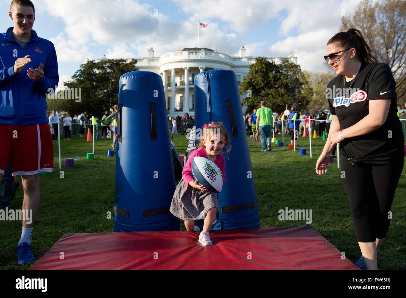A young girl tries the football obstacle course during the annual Easter Egg Roll on the South Lawn of the White House March 28, 2016 in Washington, DC. Stock Photo
