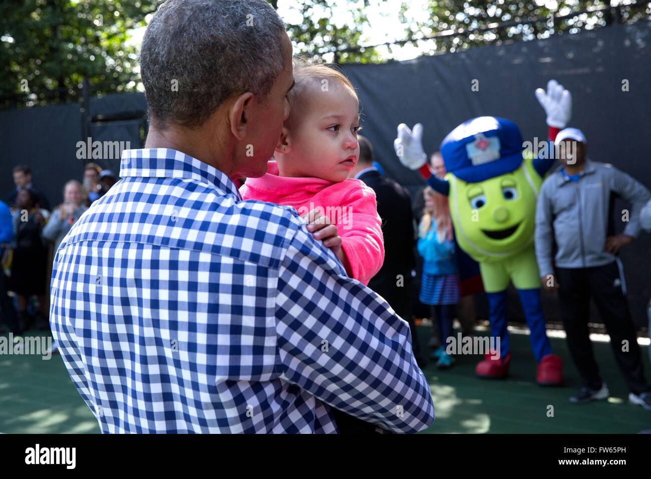 U.S President Barack Obama snuggles with 22-month-old Soleil Malveaux Jean-Pierre after participating in the tennis clinic during the annual Easter Egg Roll March 28, 2016 in Washington, DC. Stock Photo
