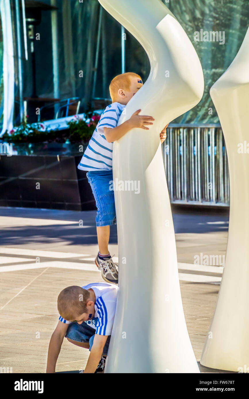 Kids playing amongst Adrian Mauriks sculpture 'Silence', public art installation, NewQuay, Docklands, Melbourne Australia Stock Photo