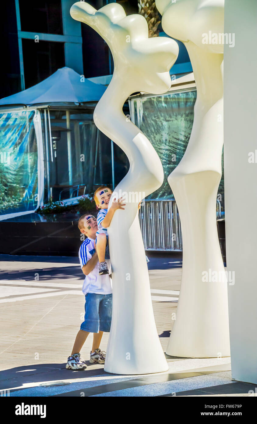 Kids playing amongst Adrian Mauriks sculpture 'Silence', public art installation, NewQuay, Docklands, Melbourne Australia Stock Photo