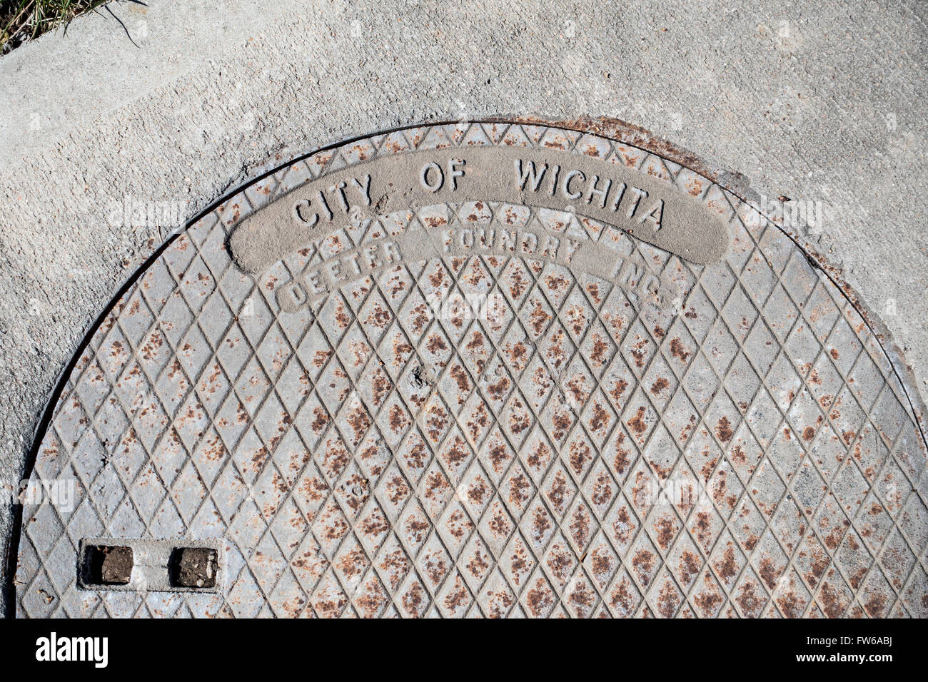 A manhole cover in an urban neighborhood in Wichita, Kansas, USA. Stock Photo