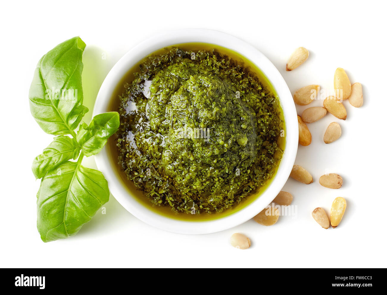 Green pesto sauce, pine nuts and basil isolated on white background, top view Stock Photo