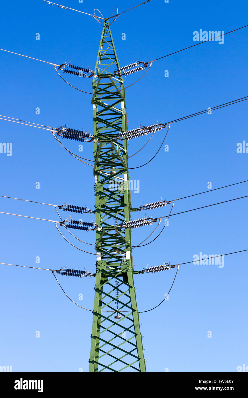 a high voltage power pylons against blue sky and sun rays Stock Photo ...