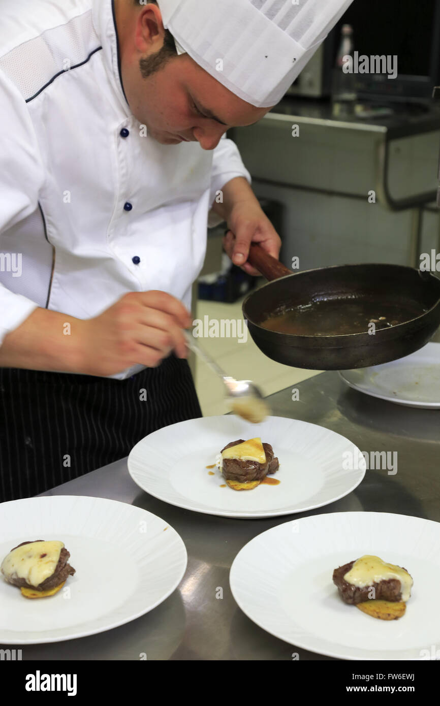 A chef preparing meat dishes in his kitchen,Gubbio,Umbria,Italy Stock