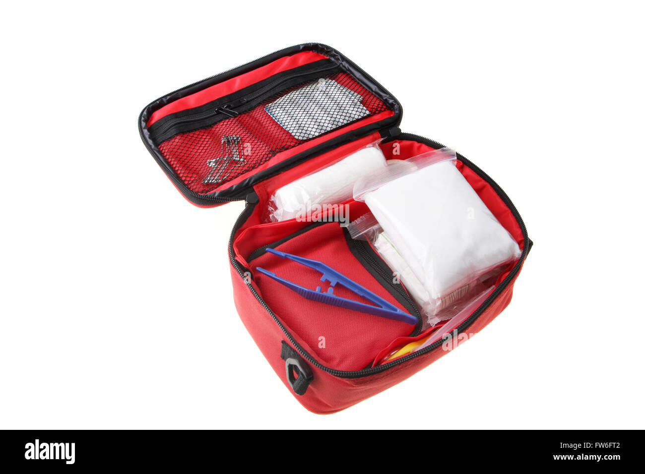 First Aid Kit showing bandages, tweezers; safety pins in a red soft case isolated on white background. Stock Photo