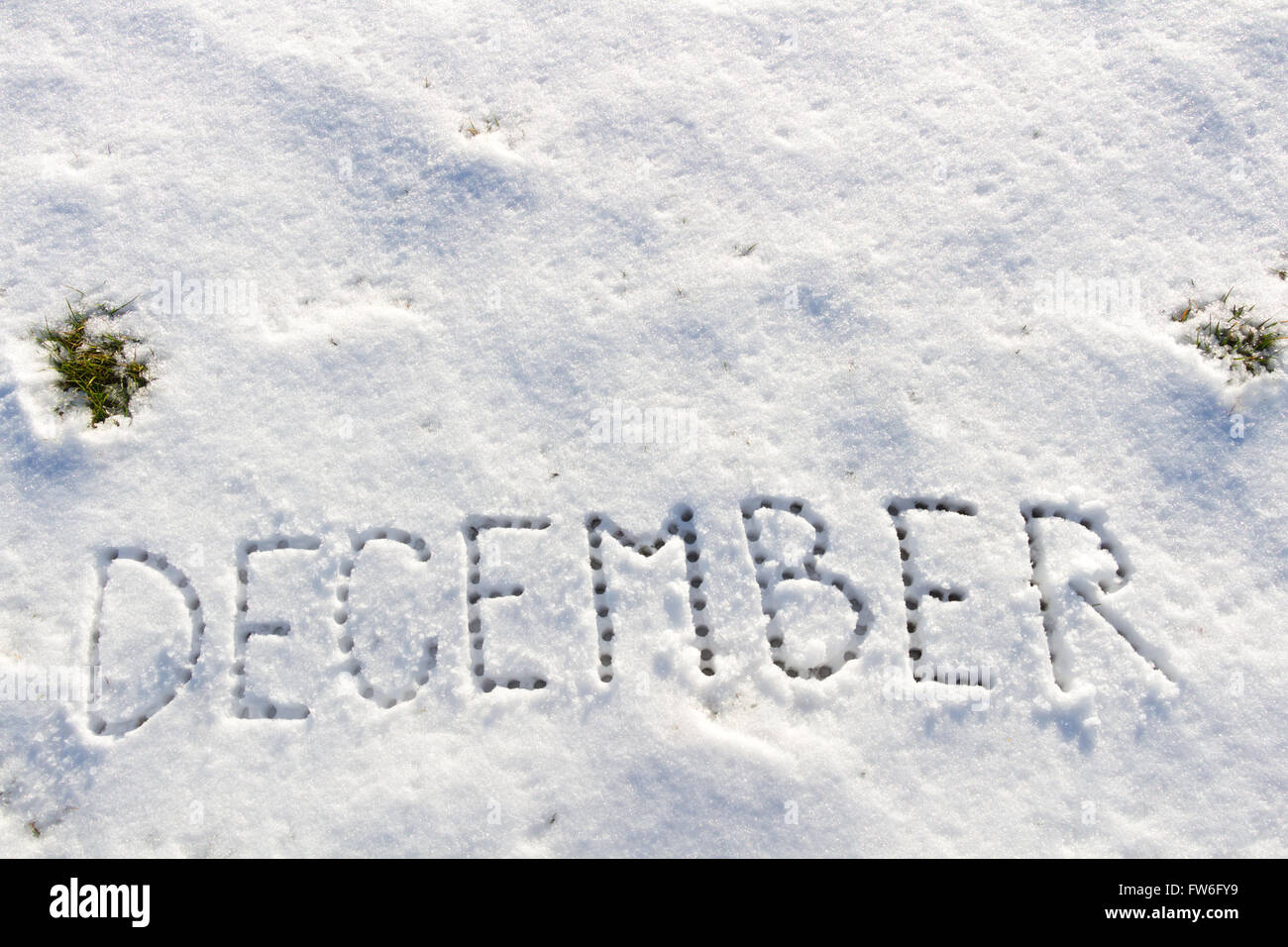 Written words December on a snow field. Stock Photo