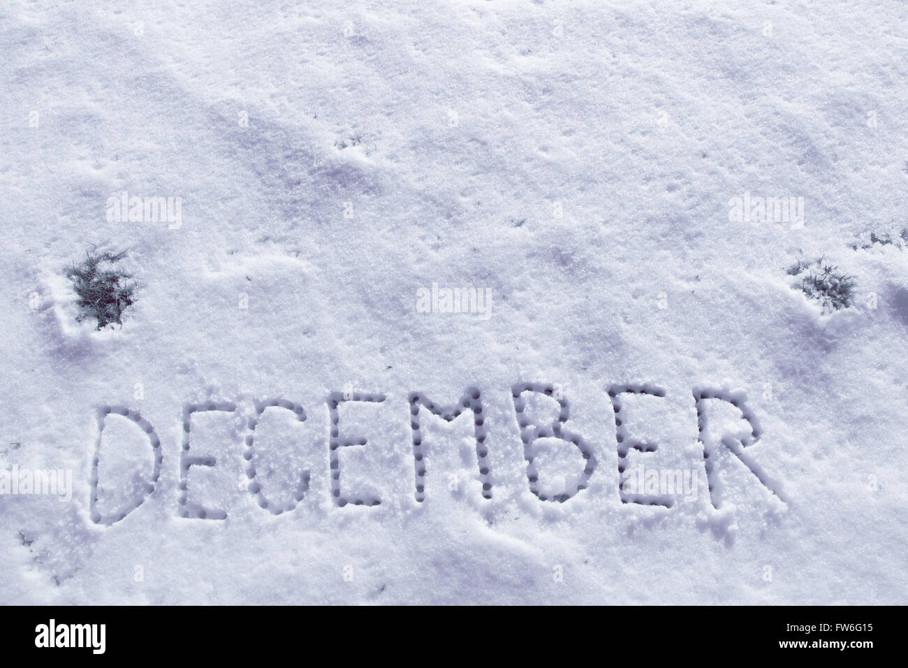 Written words December on a snow field. Stock Photo